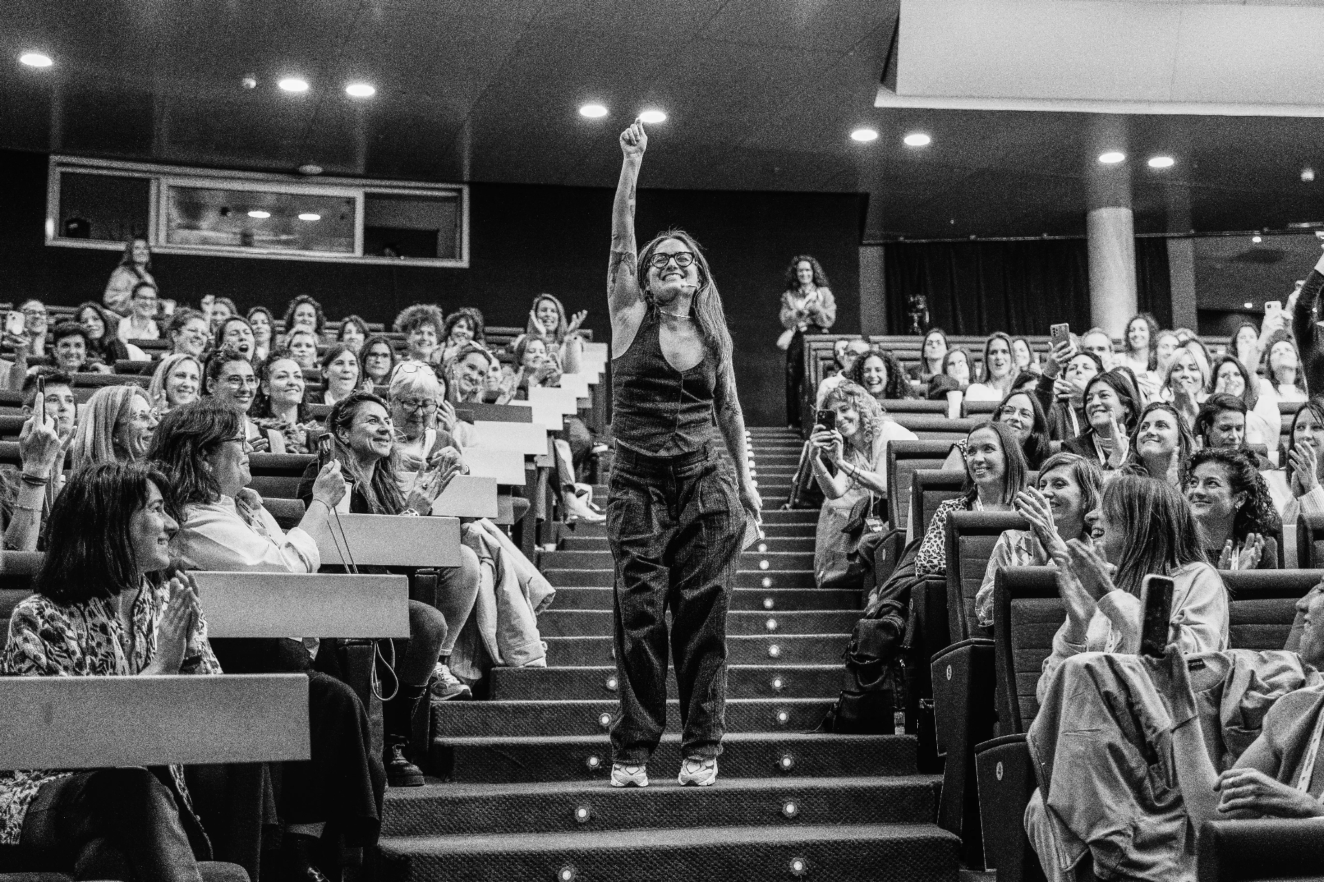 Emotive corporate event photography in Barcelona: speaker receiving an ovation in an auditorium