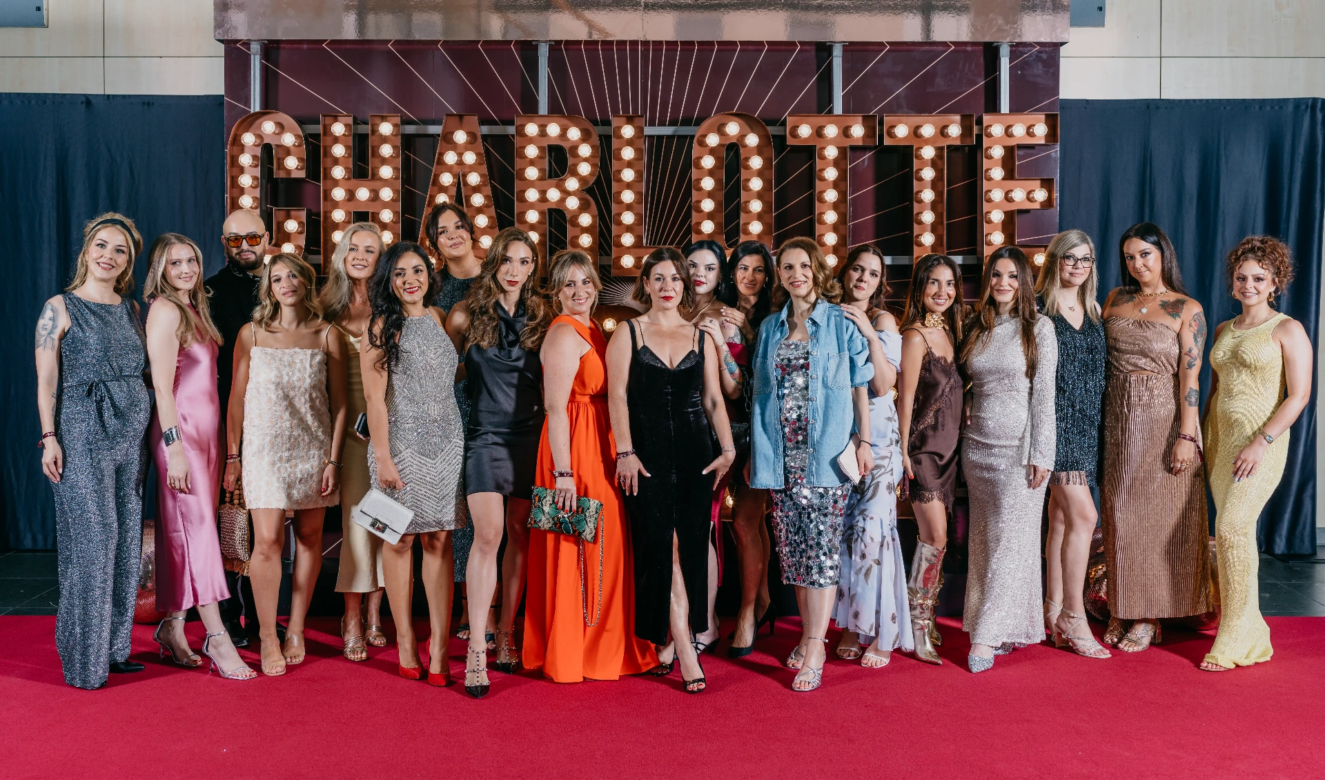 Grupo de asistentes posando en la alfombra roja de un evento corporativo en Barcelona. ©Piña Colada